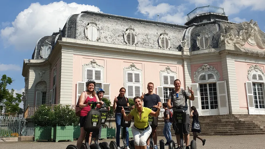 People riding segways in front of a palace.