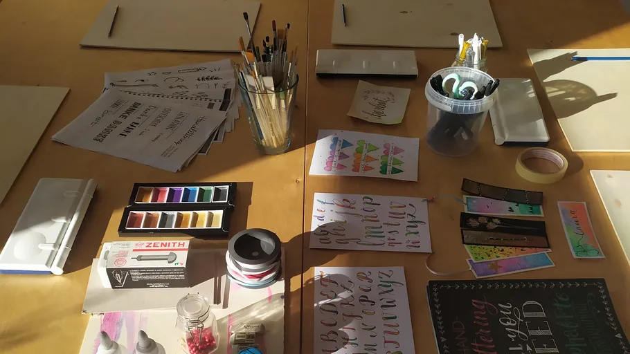 Art supplies arranged on a wooden table.