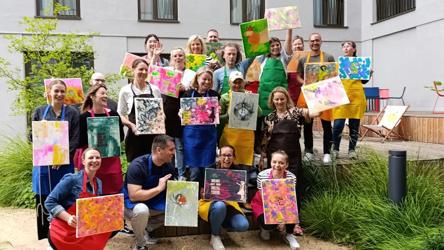 Gruppe hält bunte Gemälde im Freien.