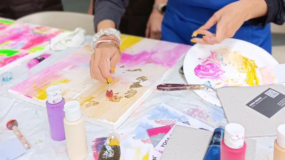 Person painting colorful art on canvas.