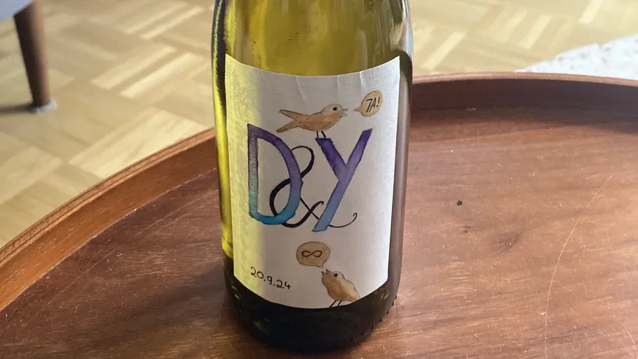 Wine bottle with decorative label on table.