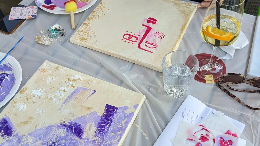 Kunstmaterialien und Gemälde auf einem Tisch.