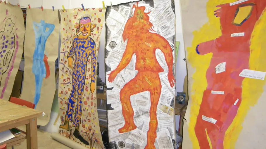 Bunte Figuren auf großen Papierbögen gemalt.