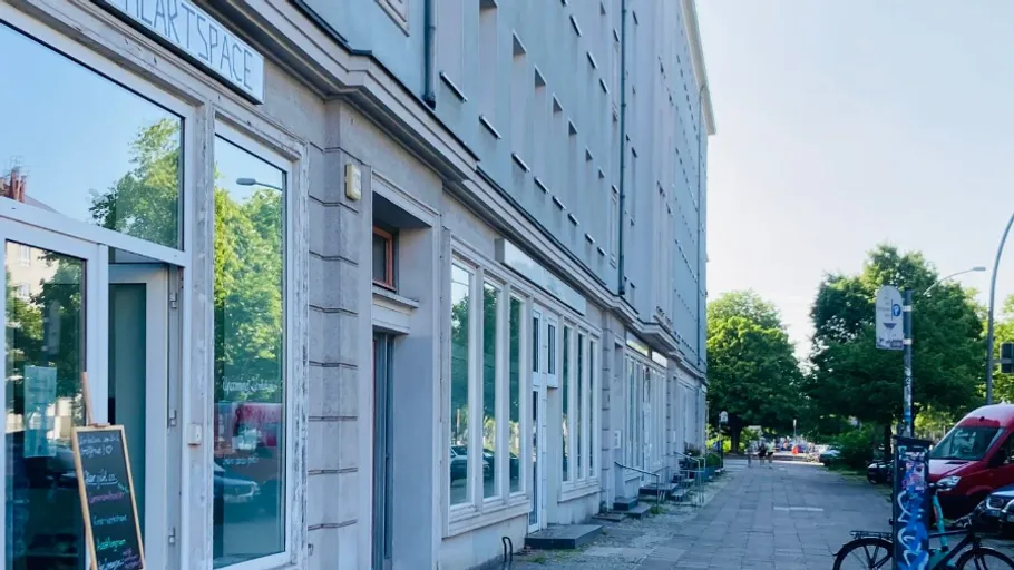 Straßenansicht mit Geschäften und Bäumen.