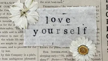 Text 'love yourself' with white flowers.