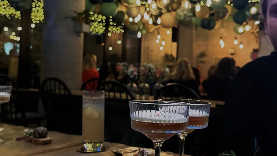 Cocktails on table in a cozy, decorated cafe.