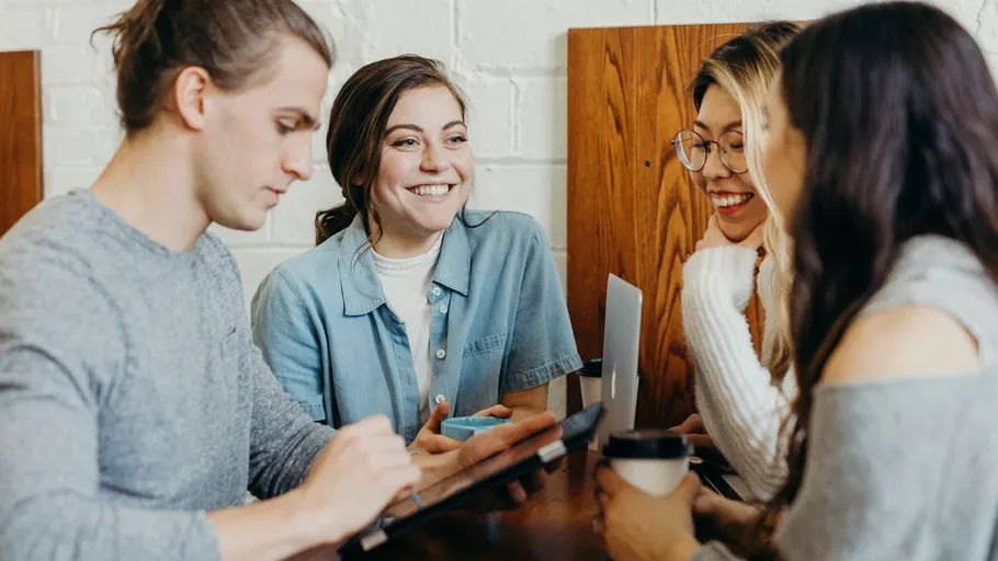 Group of four people talking at a table.