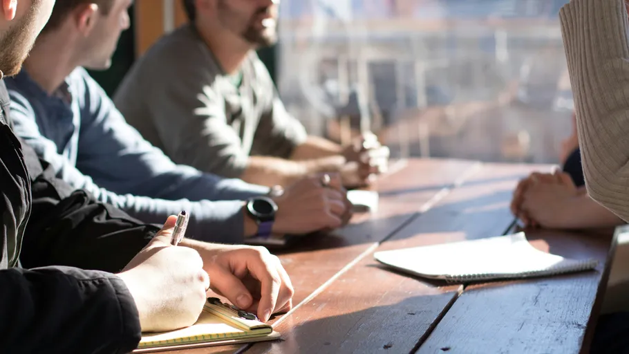 People having a meeting around a table.