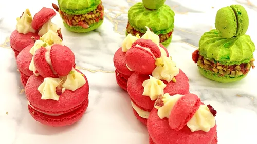 Rote und grüne Macarons auf Marmortisch.