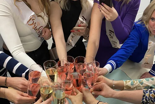 Frauen stoßen mit Sekt bei Party an.