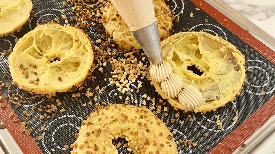 Croissant-Deckel mit Sahne auf einem Blech gefüllt.