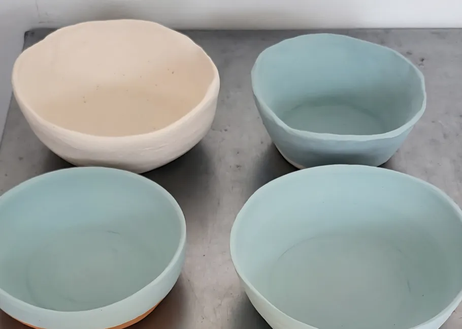 Four ceramic bowls on a gray surface.