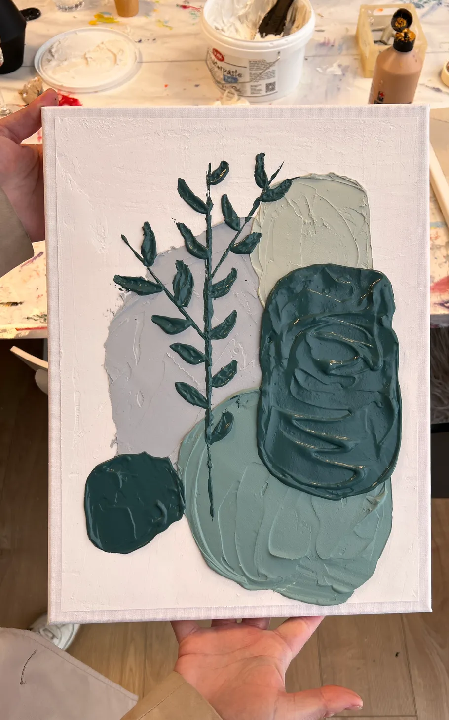 Abstract painting with textured leaves on canvas.