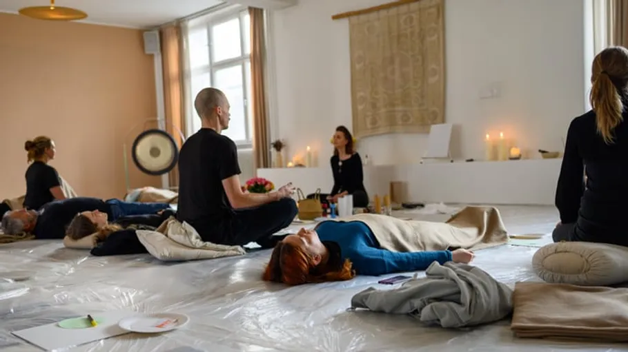 Menschen meditieren in ruhiger Raumatmosphäre.