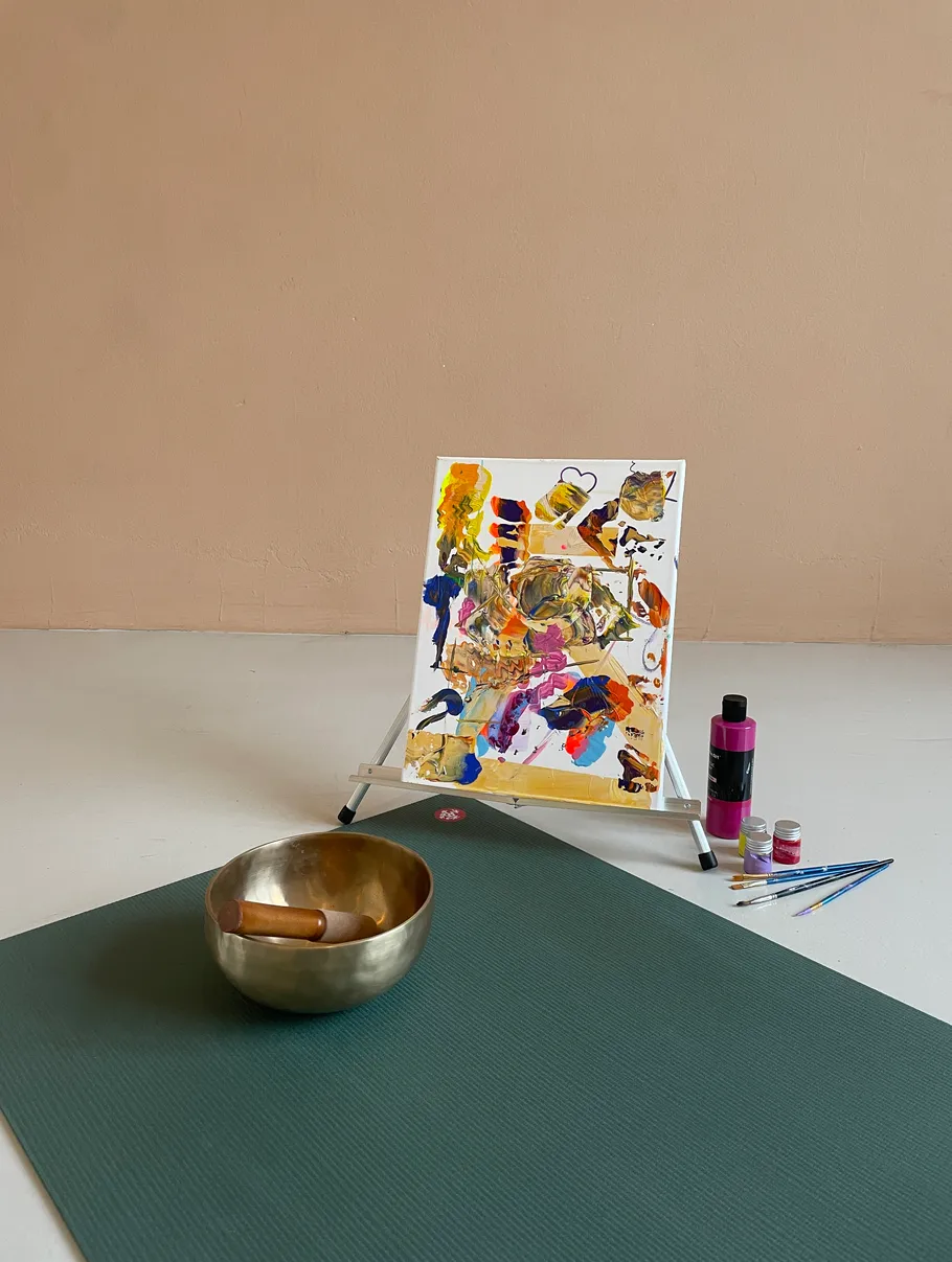 Painting on easel, yoga mat, singing bowl.