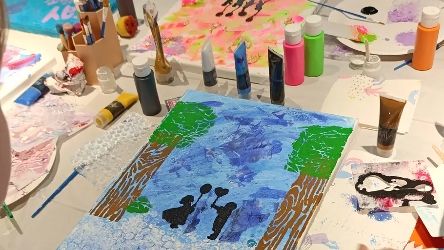 Kunstmaterialien und Gemälde auf einem Tisch.