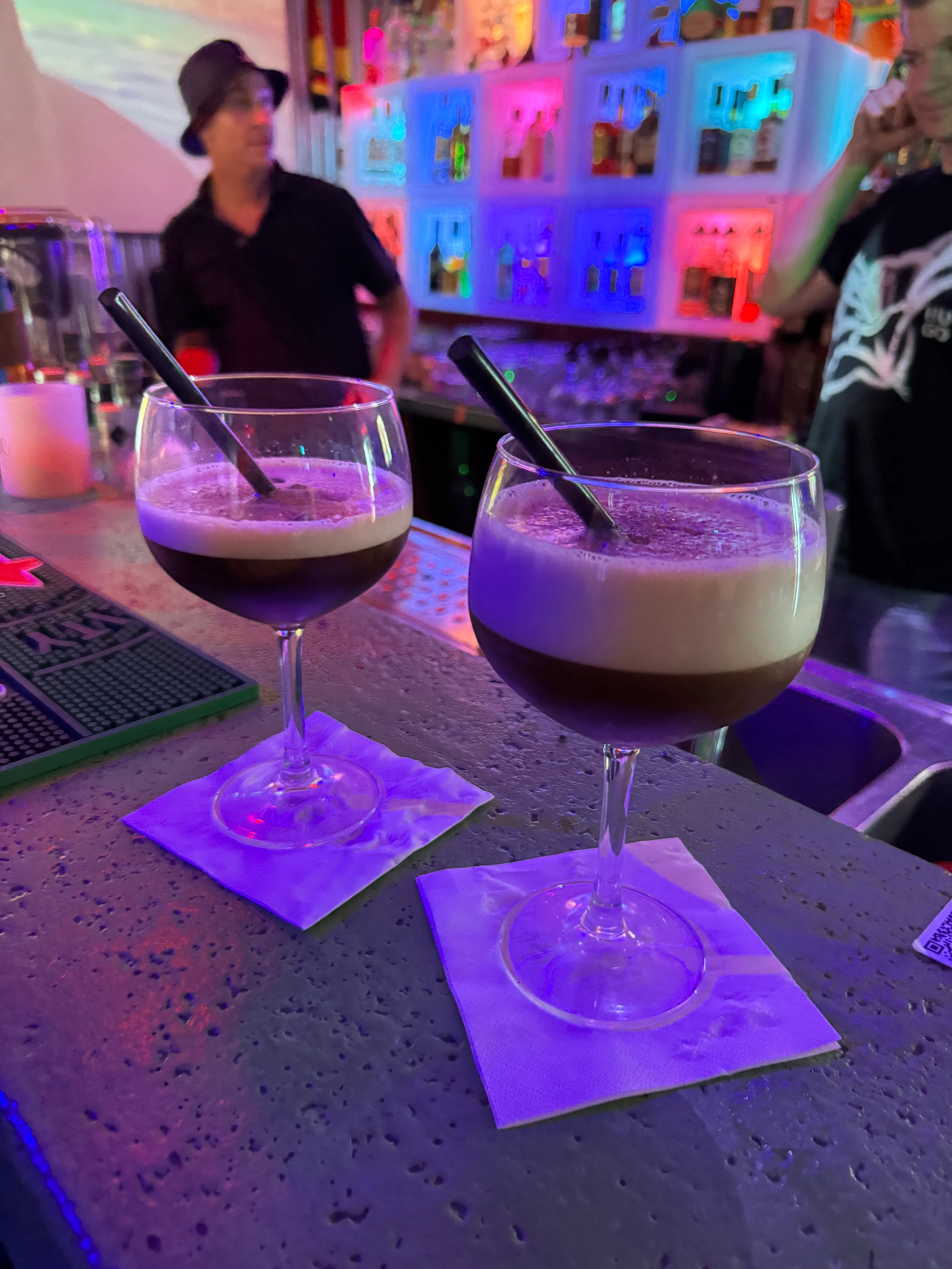 Two cocktails on a bar counter.