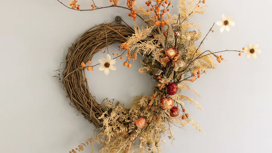 Decorative wreath with dried flowers on wall.