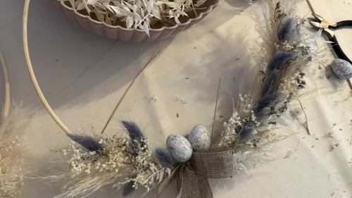 Floral wreath with eggs, on table.
