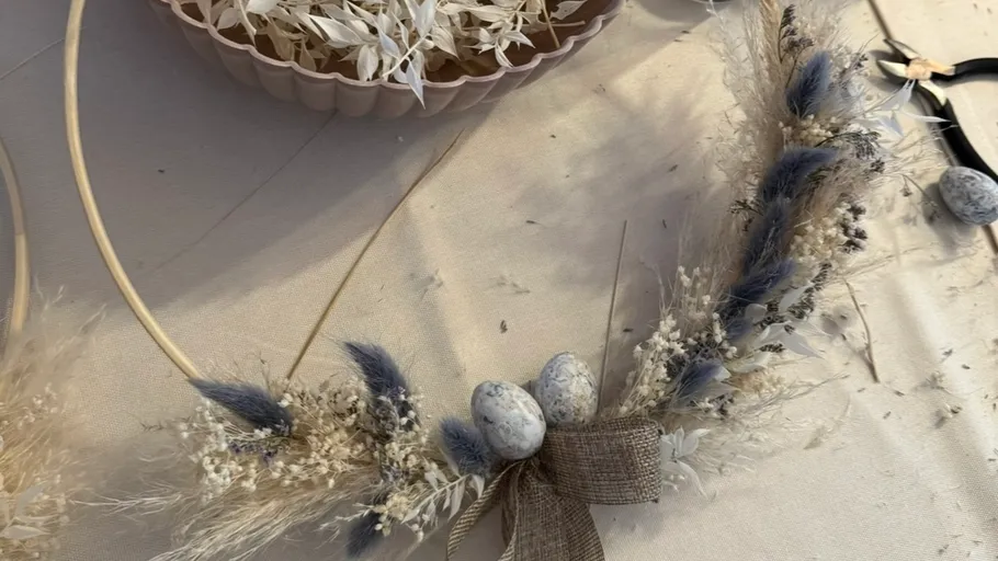 Floral wreath with eggs, on table.