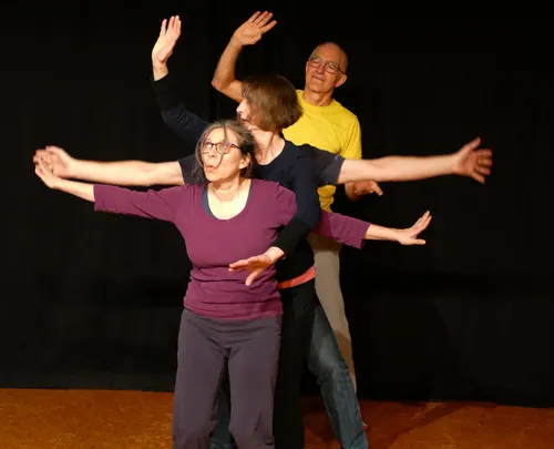 Four people forming an artistic pose on stage.