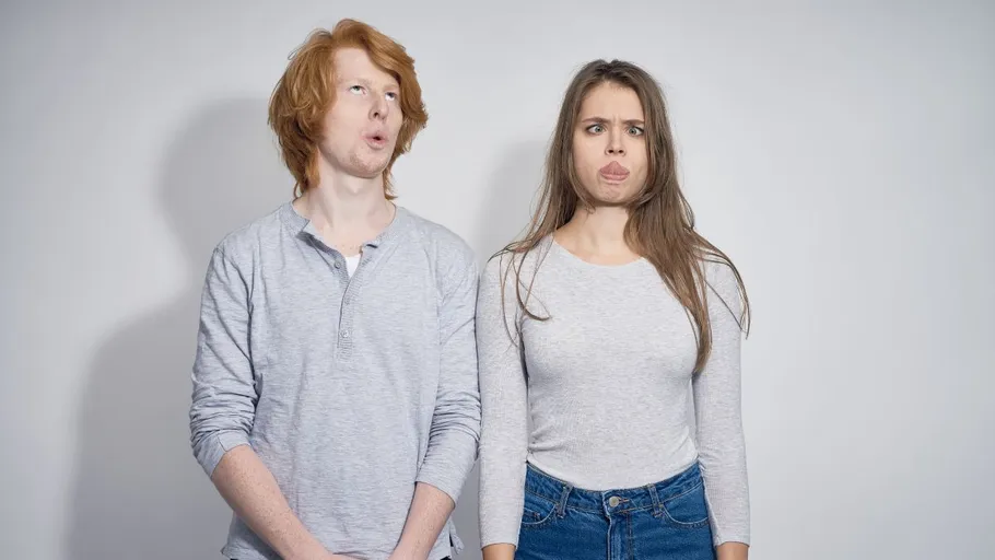 Two people making funny faces indoors.