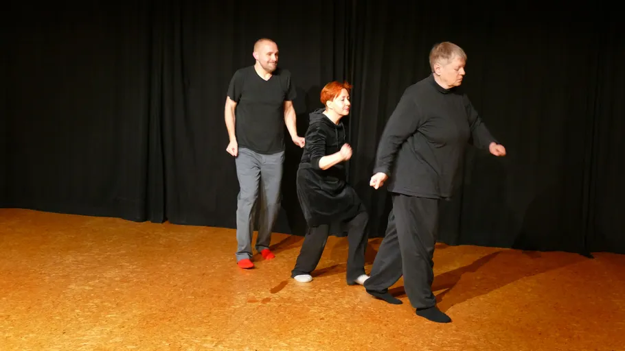 Drei Personen führen eine Theatervorstellung auf der Bühne auf.
