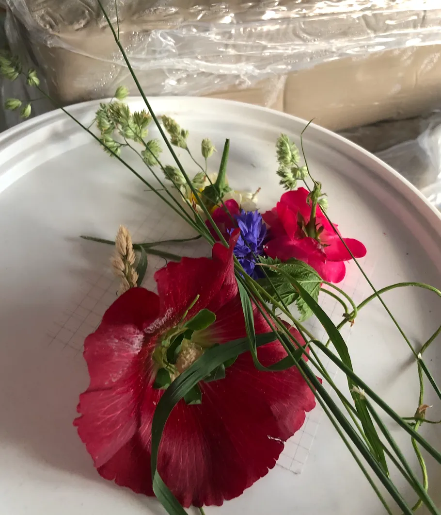 Flowers arranged on a round white surface.
