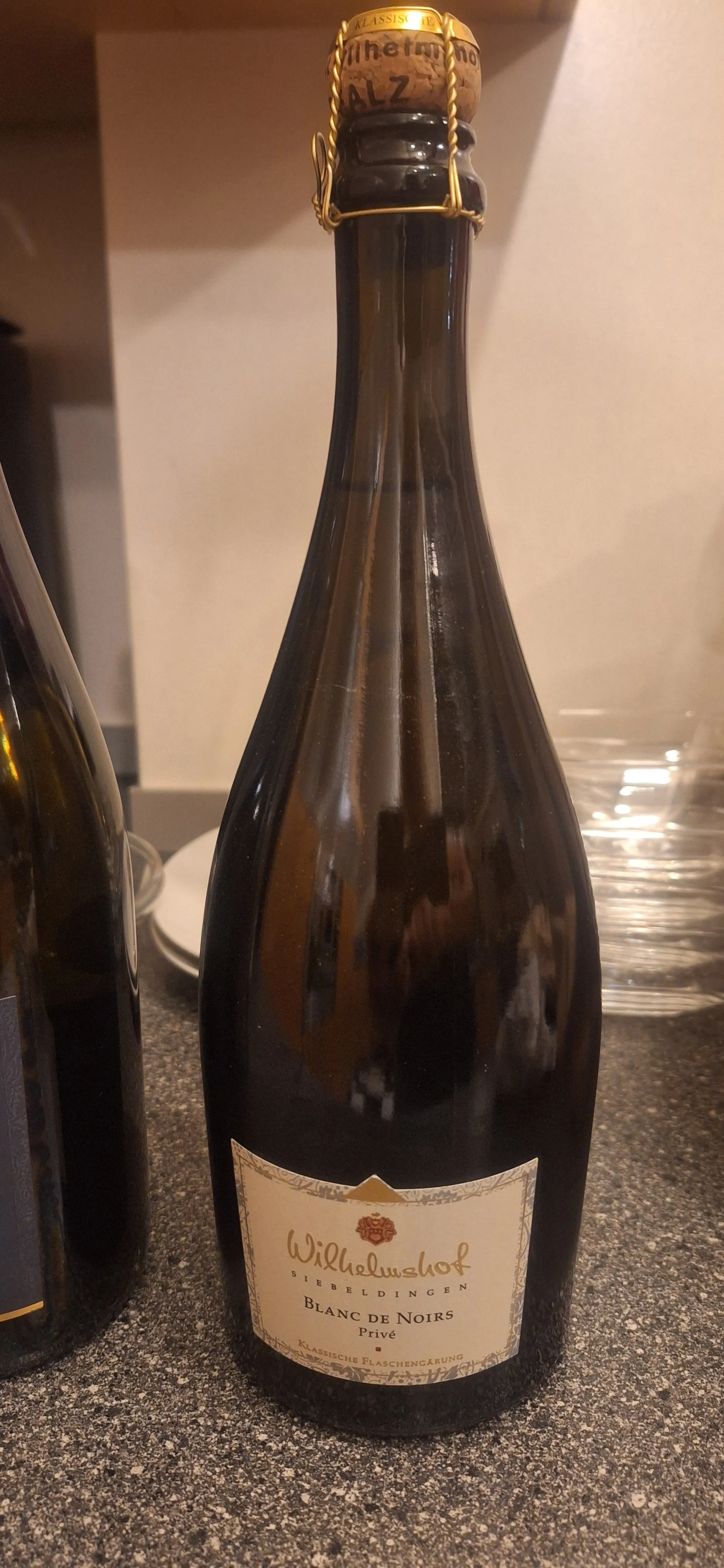 Weinflasche auf Küchentheke, Korken gesichert.