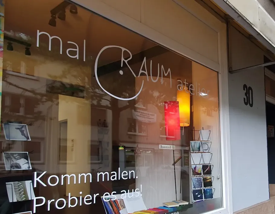 Schaufenster mit 'mal RAUM atelier' Beschriftung.