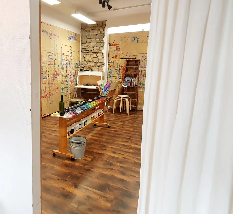Art studio with paints and canvases, colorful walls.