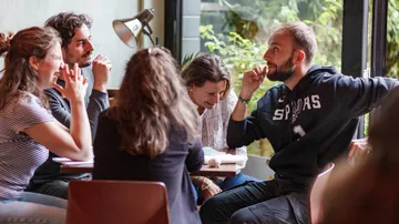 Gruppe unterhält sich an einem Tisch im Café.