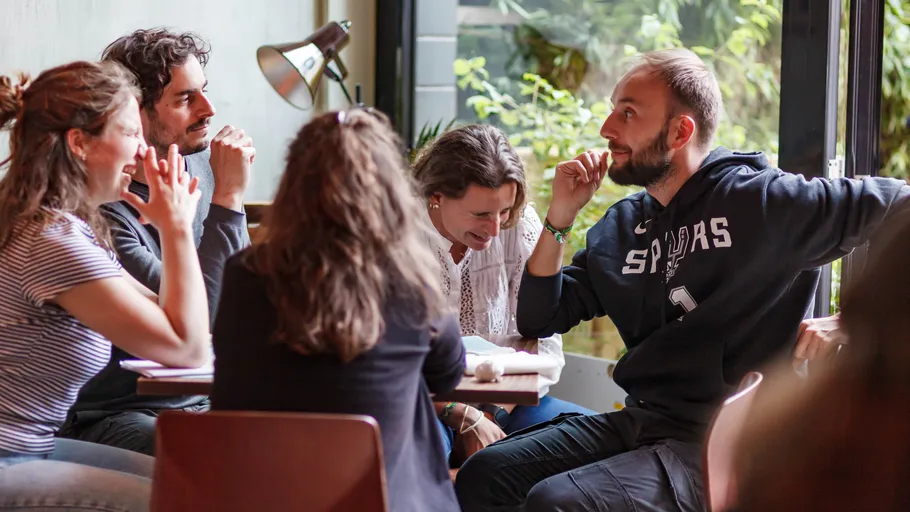 Group chatting at a table in a cafe.
