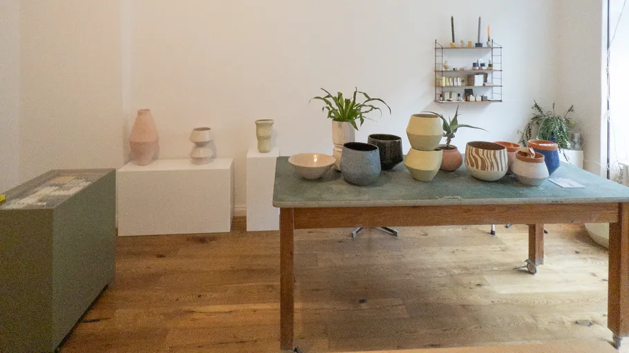 Ceramic pots displayed on a wooden table indoors.