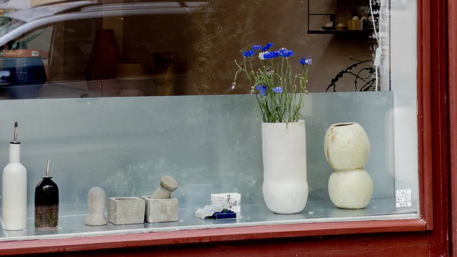 Ceramic vases with flowers in a shop window.