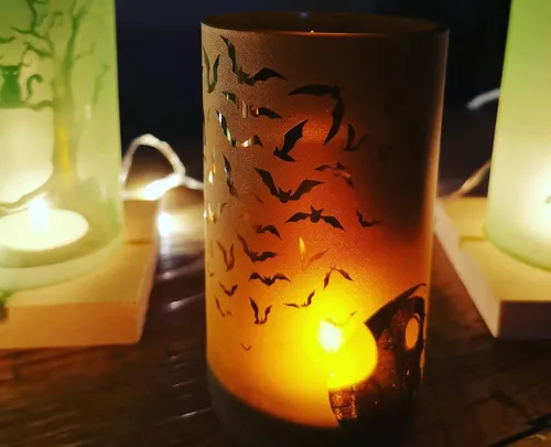 Candles with bat patterns glowing in darkness.