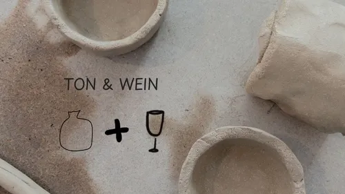 Tonschalen und Text auf sandiger Oberfläche.