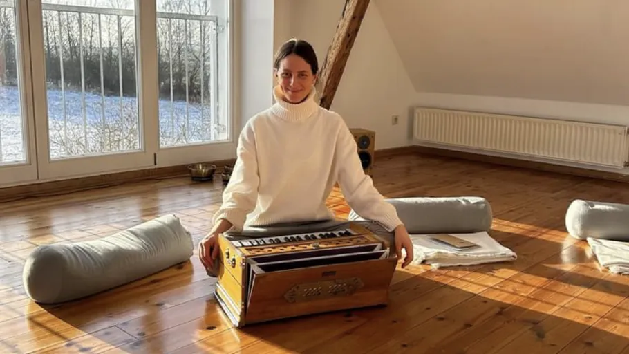 Person playing an instrument in a sunlit room.