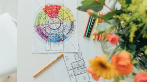 Color wheel and architectural sketches on table.