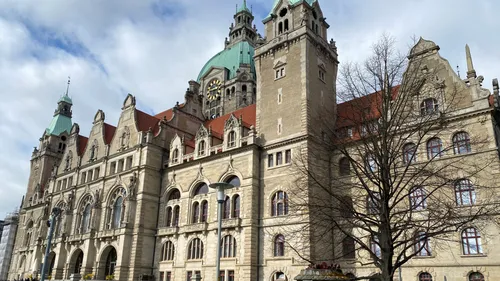Historisches Gebäude mit Uhr, bewölkter Himmel.