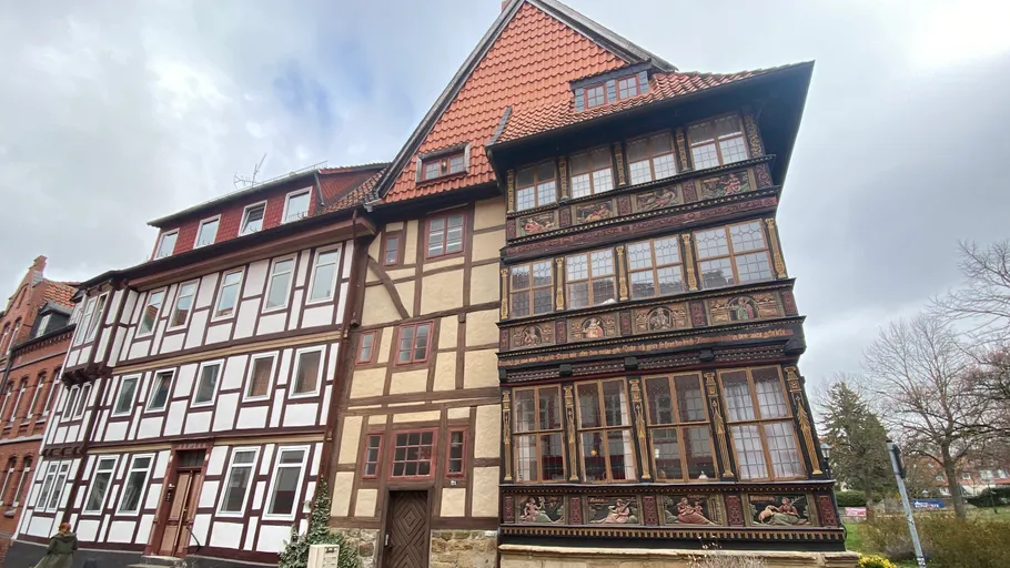 Fachwerkhaus mit kunstvollen Verzierungen, bewölkter Himmel.