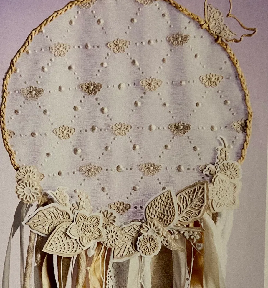 Lace dreamcatcher with floral decorations, indoors.
