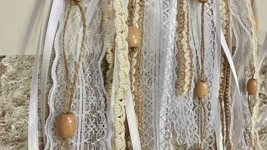 Lace and ribbons with wooden beads hanging.