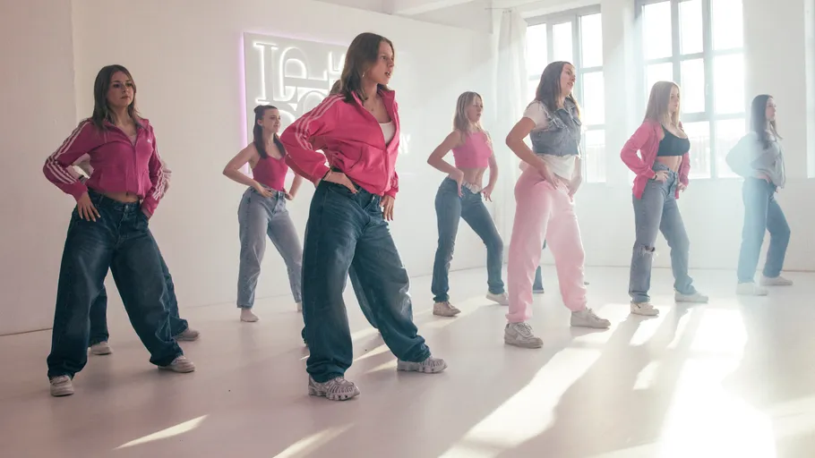 Gruppe von Frauen tanzt in einem hellen Raum.