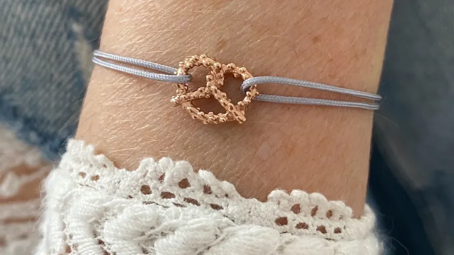 Armband mit Brezel-Anhänger am Handgelenk.
