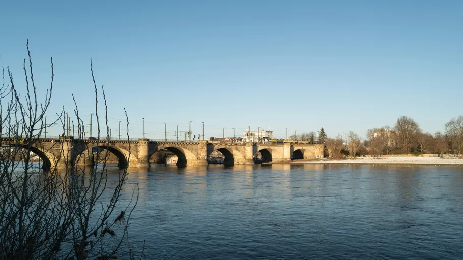 Stone bridge over a calm river, clear sky.