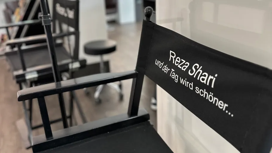 Schwarze Stühle mit Text in einem Salon.