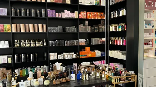 Perfume bottles displayed on shelves in store.