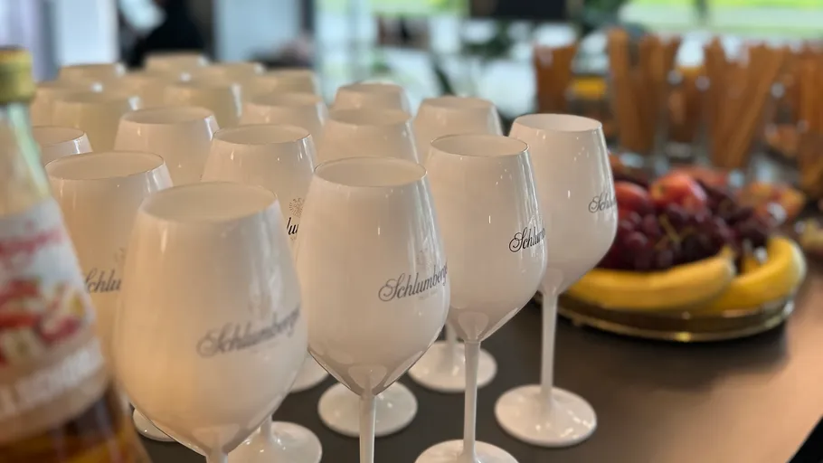 White wine glasses on table, fruit platter nearby.