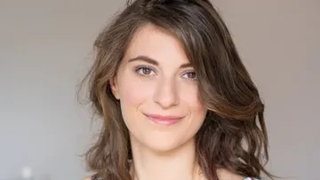Woman smiling, with brown shoulder-length hair.